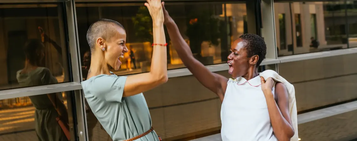 Deux femmes souriantes se tapent dans la main - Two smiling women giving a high five