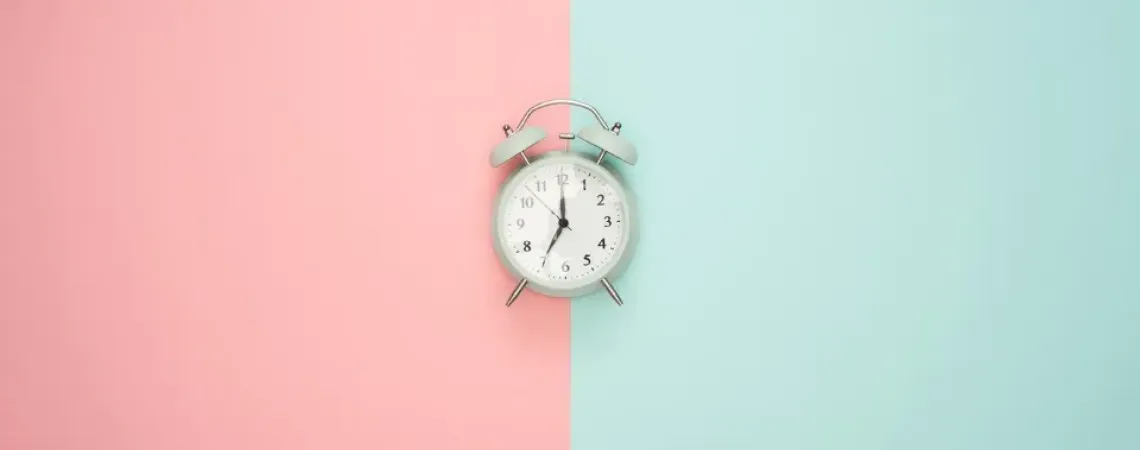 clock in the middle of a background pink and turquoise