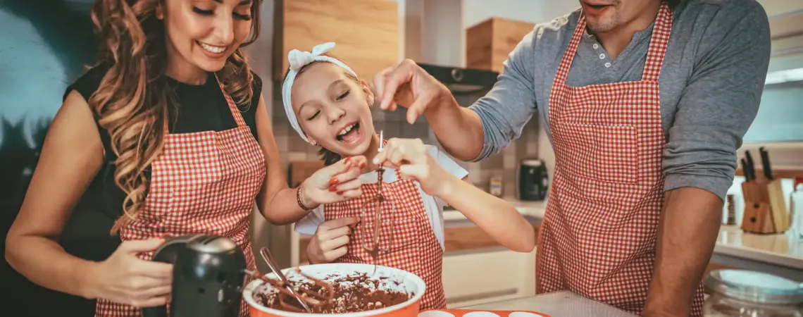 Famille souriante en train de cuisiner un dessert - Smiling family cooking a dessert together