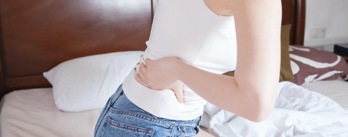 Person holding her lower back because of chronic pain