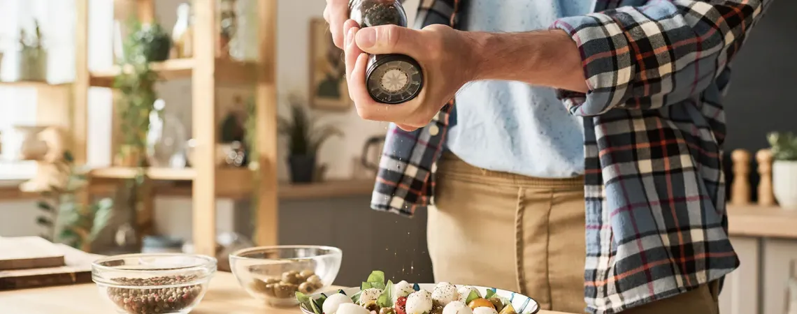 Homme ajoutant épices sur salade - Man adding spices on salad