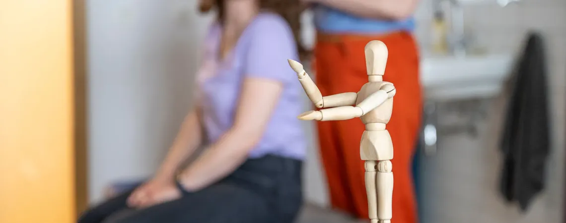 A wooden mannequin in focus on a table - Un mannequin en bois net sur une table