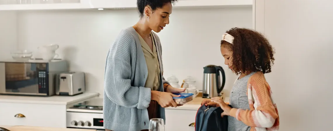 Maman préparant une boîte à lunch pour sa fille - Mom packing a lunchbox for her daughter
