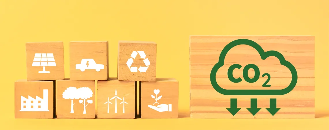 stacked wooden blocks with ecological shapes painted white on a yellow background