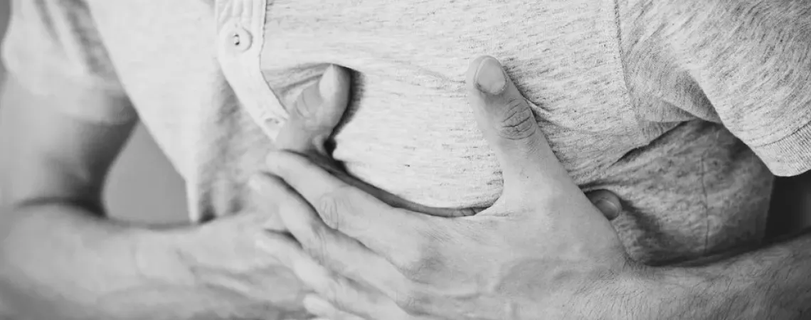 Man with hands on his chest because of acid reflux