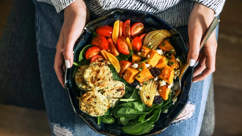 Assiette végane tenue par une femme - Vegan plate held by a woman