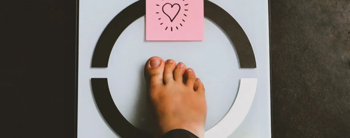 Pied sur une balance avec post it coeur - Foot on scale with a heart post it