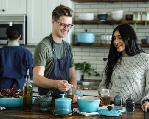 man and woman smiling as they cook