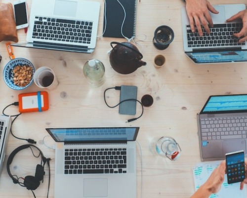 Ordinateurs et portables sur un bureau avec café