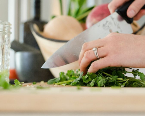 woman cutting parsley with chef's knife