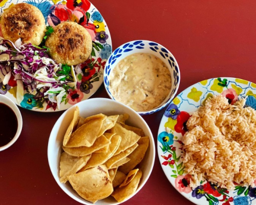 rice, patties and chips in dishes on a red background