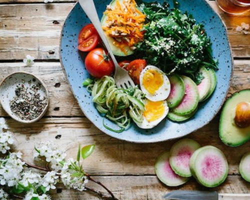 bowl of greens with eggs and tomatoes