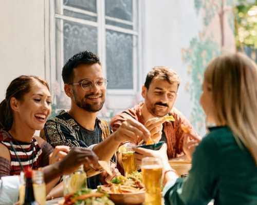 A group of friends enjoying a meal together at Nepan, Ottawa, sharing food and drinks in a casual, social setting.