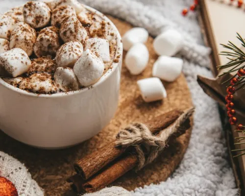 hot chocolate with marshmallows on a table decorated for Christmas