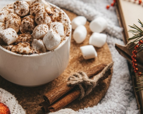hot chocolate with marshmallows on a table decorated for Christmas