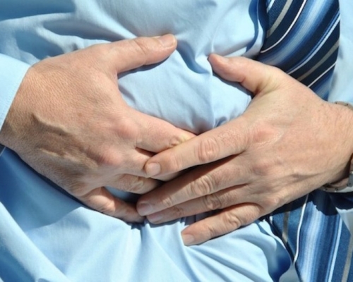 Man with a blue shirt having abdominal pain