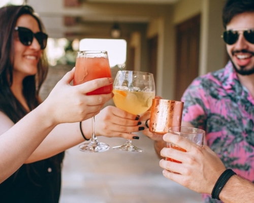 women and men in summer with a cocktail in their hands