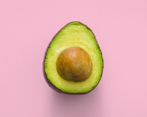 avocado in front of a pink background