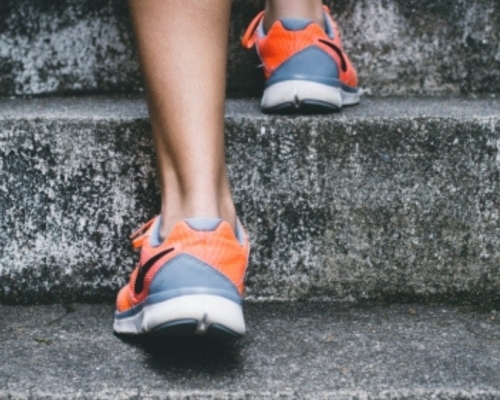 a person climbing the stairs in sports shoes