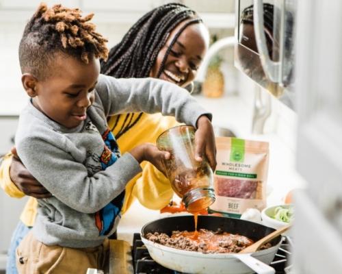 mother and son smiling and cooking