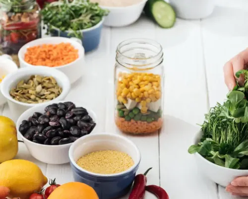 A person is holding a bowl of vegetables and other healthy ingredients for cholesterol management