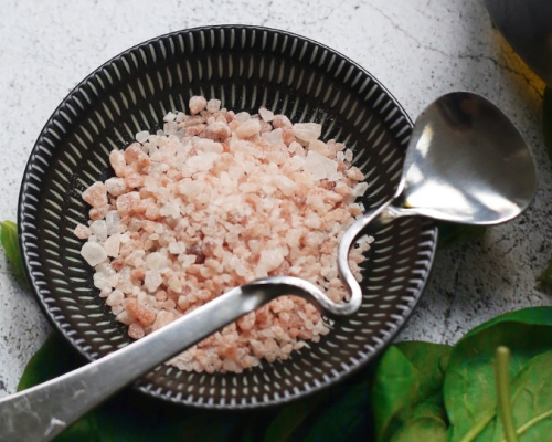 bowl of Himalayan salt with spinach on the side