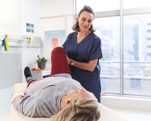 Physiotherapist assisting a patient with a leg stretch -  Physiothérapeute aidant un patient à étirer la jambe