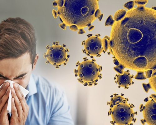 a man blowing his nose beside coronavirus