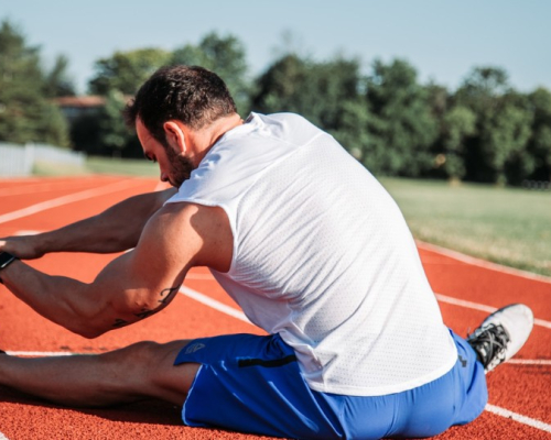 A person stretching on a racetrack