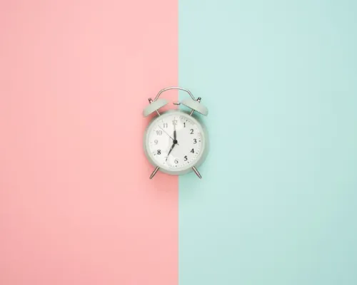 clock in the middle of a background pink and turquoise