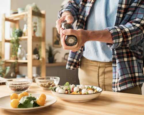 Homme ajoutant épices sur salade - Man adding spices on salad