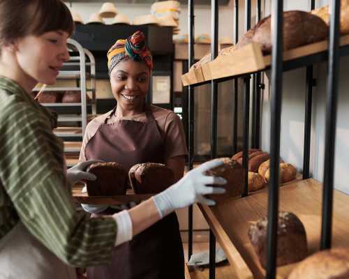 Two bakers arranging fresh loaves of bread - Deux boulangères disposant des pains frais