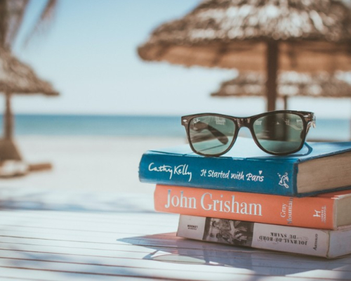 Pile of books with a view on the ocean 