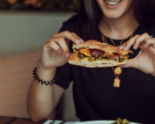 Woman eating mindfully her sandwich at a restaurant