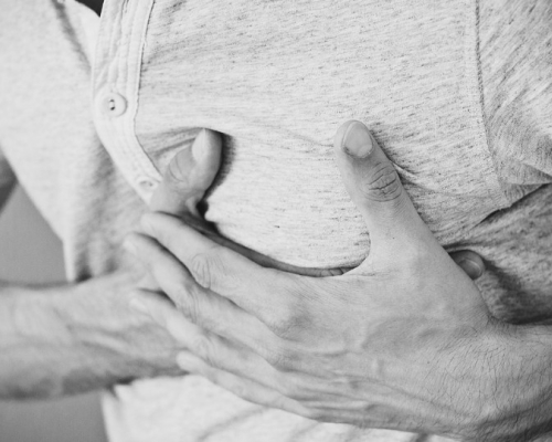 Man with hands on his chest because of acid reflux