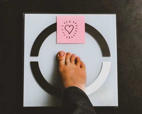 Pied sur une balance avec post it coeur - Foot on scale with a heart post it