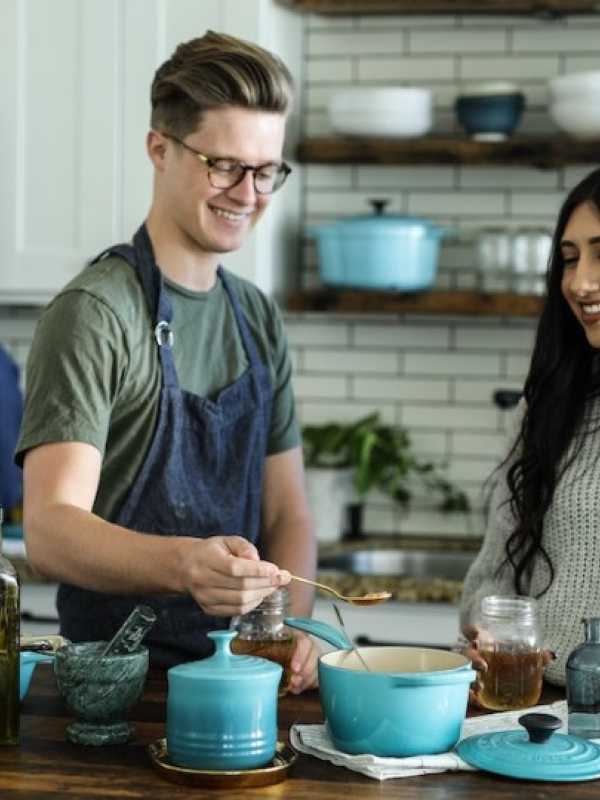 man and woman smiling as they cook