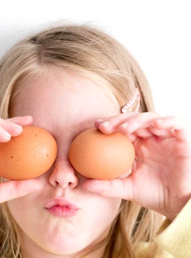 child hiding his eyes with eggs