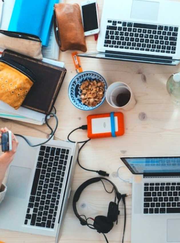 Ordinateurs et portables sur un bureau avec café