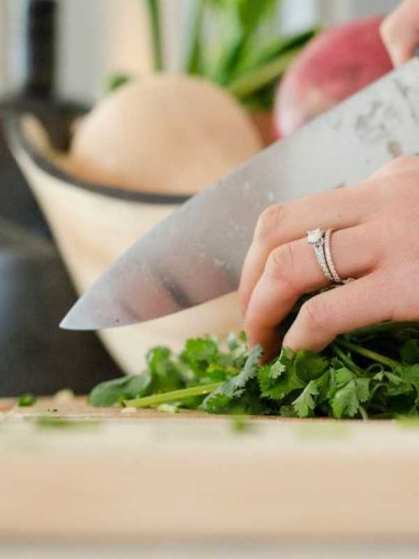 woman cutting parsley with chef's knife
