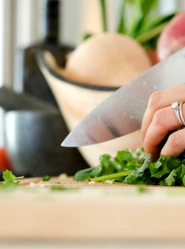 woman cutting parsley with chef's knife