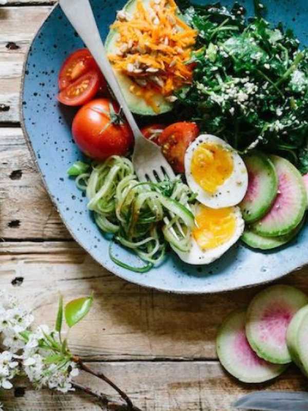 bowl of greens with eggs and tomatoes