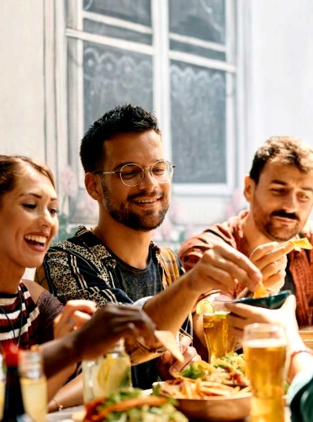 A group of friends enjoying a meal together at Nepan, Ottawa, sharing food and drinks in a casual, social setting.