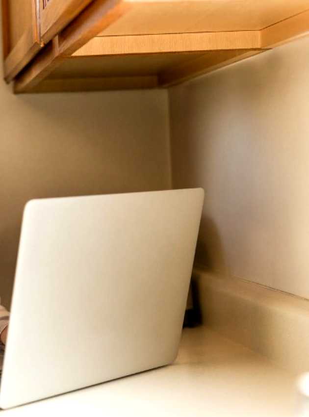 menopausal woman in front of a computer with a glass of milk