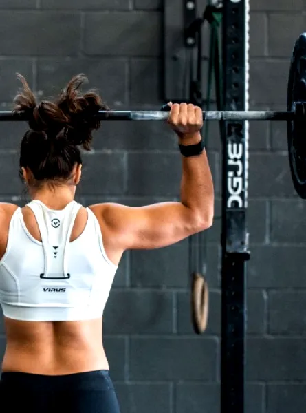 woman with muscular back lifting a dumbbell