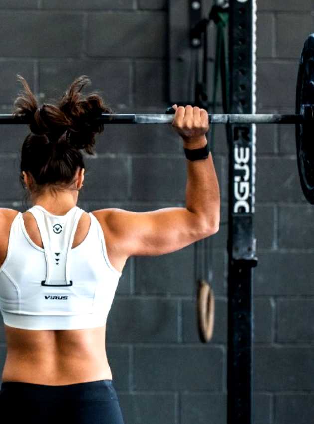 woman with muscular back lifting a dumbbell