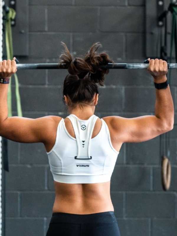 woman with muscular back lifting a dumbbell