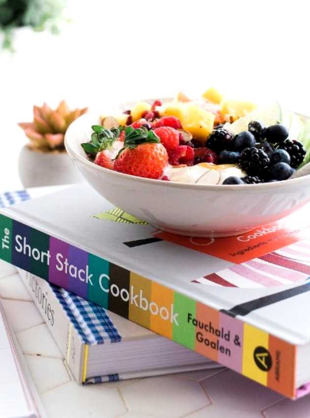 bowl of fruit on a pile of books