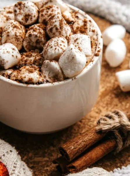 hot chocolate with marshmallows on a table decorated for Christmas