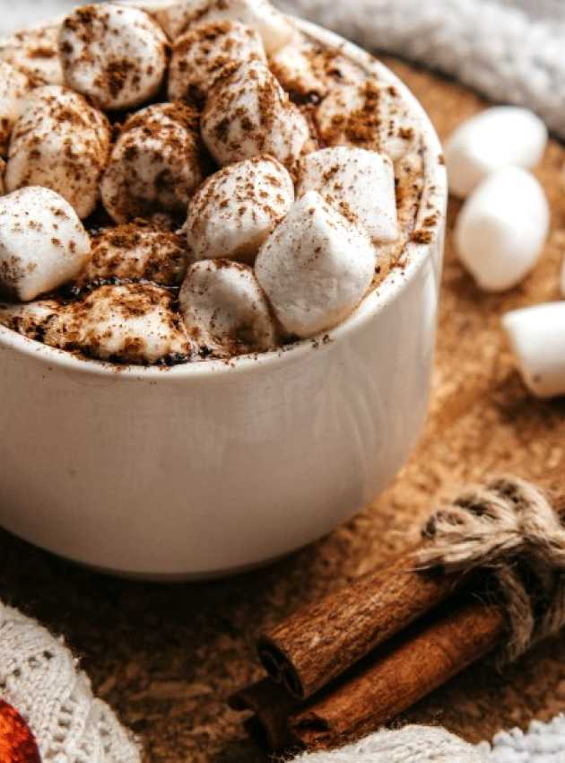 hot chocolate with marshmallows on a table decorated for Christmas